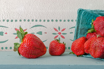 Fresh strawberries on a shelf. Suggesting late spring or home gardening.