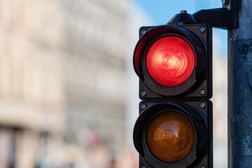 close-up of traffic semaphore with red light on defocused city street background with copy space