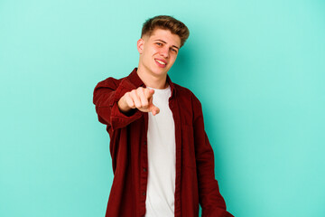 Young caucasian man isolated on blue background pointing to front with fingers.