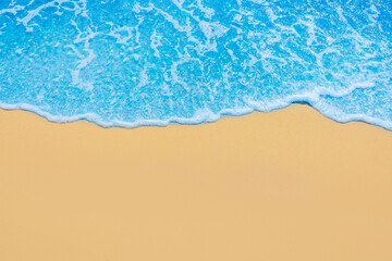 Fototapeta na wymiar Blue sea water on light yellow beach sand