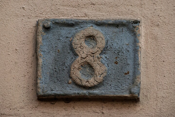 Old retro weathered cast iron plate with number 8 closeup