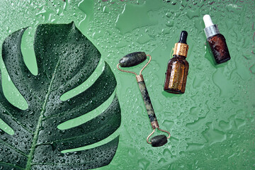 Beauty cosmetic lotion serum bottle and jade massage roller. Treatment skincare concept with...