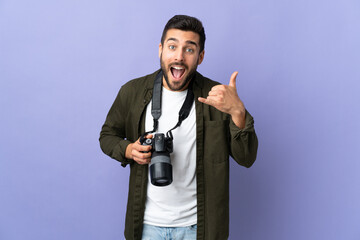 Photographer man over isolated purple background making phone gesture. Call me back sign