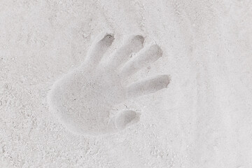 A handprint or a trail on the white beach sand background close-up