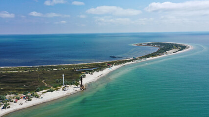 Aerial drone top down photo of seascape of island with sandy beach, turquoise clear waters of black sea in Ukraine, trees and two lighthouses. island Dzharilgach