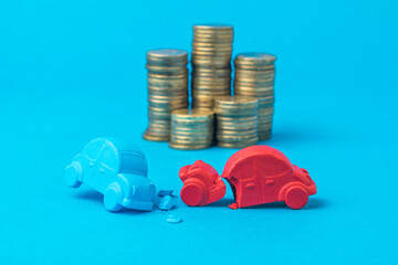 Installation of a car accident with toy cars on the background of coins.