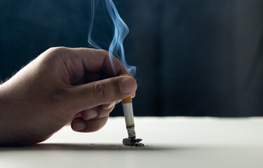 Close up hand putting out a cigarette. man extinguished his cigarette by crushing the floor. He smoked a lot of cigarettes