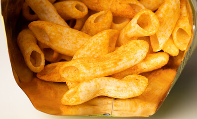 Crispy penne pasta shaped salty. Fast food or junk food snacks unhealthy concept.