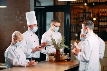 Cafe staff on morning briefing wearing protective masks.