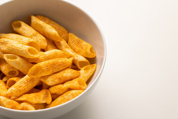 Crispy penne pasta shaped salty. Fast food or junk food snacks unhealthy concept.