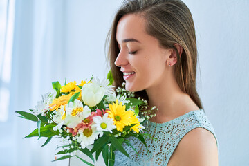 Naklejka premium Beautiful happy young smiling woman with decorative colorful bright fresh flower hat box at holiday spring women's day