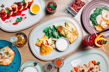 Various breakfast dishes are served on the table in the restaurant.