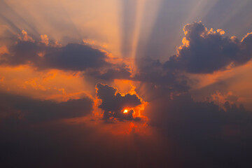 Fototapeta na wymiar Sun shines behind the cumulus clouds.Sun hiding behind a cloud on the day sky.