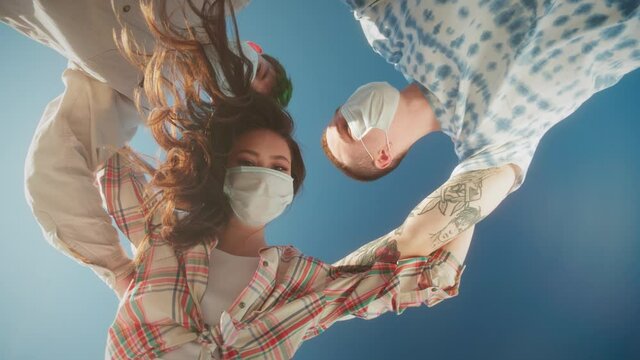 Joyful Multicultural Teenagers Standing In Circle, Young people, man and woman, medical protection safety coronavirus covid 19 masks, Low Angle. Generation z millennials have fun on party in circle