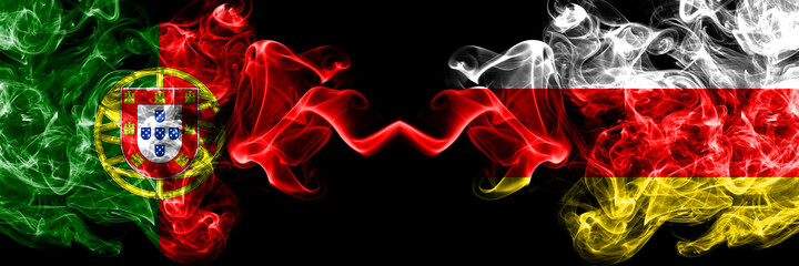 Portugal, Portuguese vs South Ossetia smoky mystic flags placed side by side. Thick colored silky abstract smoke flags.