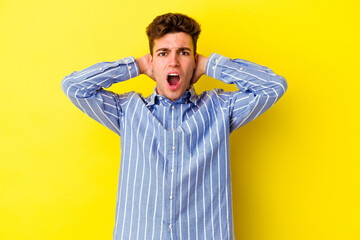 Young caucasian man isolated on yellow background screaming with rage.