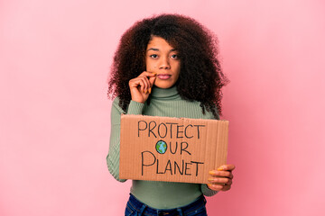 Young african american curly woman with fingers on lips keeping a secret.