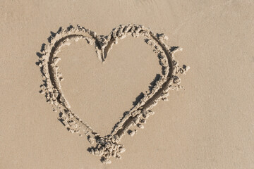 A sign or symbol of heart and love, drawn on wet beach sand close-up