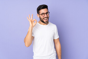 Caucasian handsome man over isolated background showing ok sign with fingers