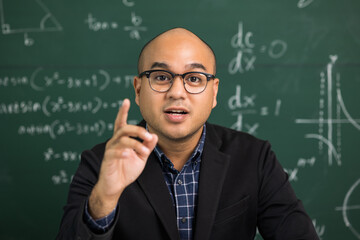 Indian young teacher man looking at camera sitting teaching online video conference live stream. Asian teacher teaching class webinar online for students learning.