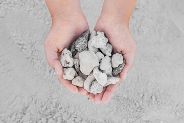 Girl's hands close up hold a pile of sea stones