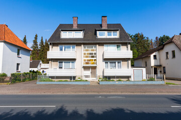 Fototapeta na wymiar Älteres Mehrfamilienhaus an einer Hauptstraße