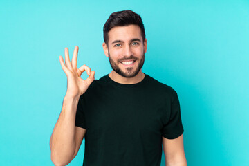 Caucasian handsome man isolated on blue background showing ok sign with fingers