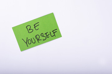 Be yourself word written on a Green color sticky note with a White background.