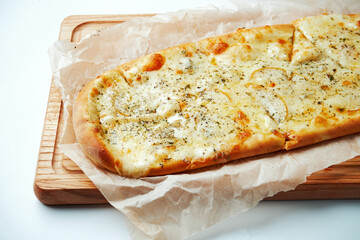 Appetizing Italian pizza 4 cheese with pear on a wooden tray on a gray background. Top view. Italian cuisine
