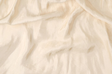 Soft smooth beige silk fabric background. Fabric texture.