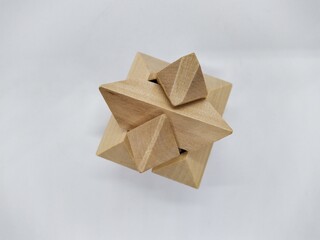 assembled and whole 3d wooden brain teaser on white background