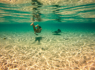 Jeune femme en plongée avec une raie, lagon à Taha'a, Polynésie française