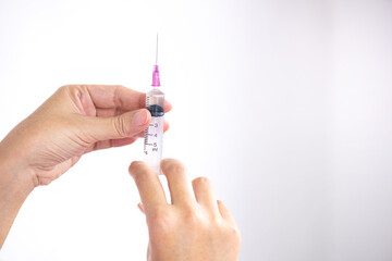 A medical injection syringe in the hand, palm or fingers Vaccination, plastic, medicine Concept of health and treatment