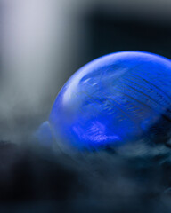 Frozen soap bubble with beautiful light and color on a wooden structure