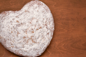 heart shaped cake, freshly baked with love, top view on a wooden table background