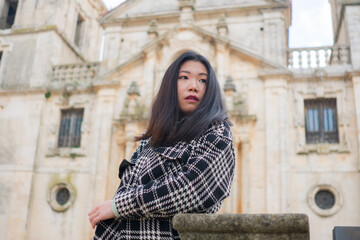 Fototapeta na wymiar Asian woman enjoying holidays as tourist in Europe - lifestyle portrait of young happy and beautiful Korean girl in autumn coat touring the city relaxed and cheerful