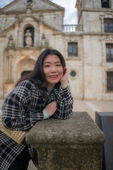 Fototapeta na wymiar Asian woman enjoying holidays as tourist in Europe - lifestyle portrait of young happy and beautiful Korean girl in autumn coat touring the city relaxed and cheerful