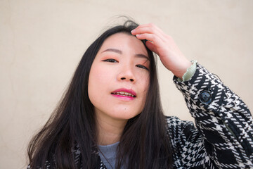 natural portrait of young happy and beautiful Asian Japanese woman in chic  Autumn coat smiling...