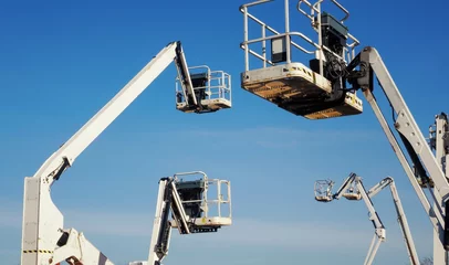 Foto auf Alu-Dibond multiple hydraulic telescopic boom lifts or cherry pickers rising into the blue sky © Jarama