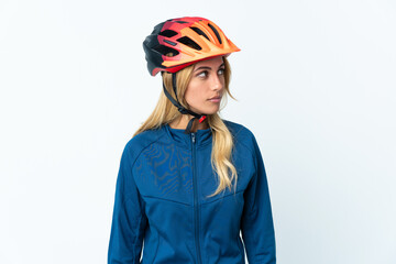 Young blonde Uruguayan cyclist woman isolated on background looking to the side