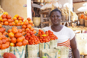 Happy African woman selling fruits and vegetables at the farmers market