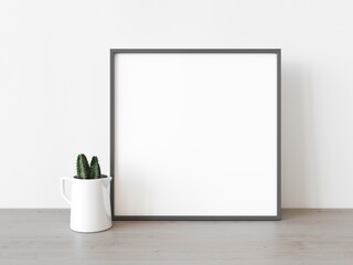 Empty grey square frame stands on light wood table against wall. Mockup of poster frame close up in home interior with succulent plant, 3D illustration