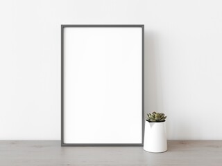 Empty grey rectangular vertical frame stands on light wood table against wall. Mockup of poster frame close up in home interior with succulent plant, 3D illustration