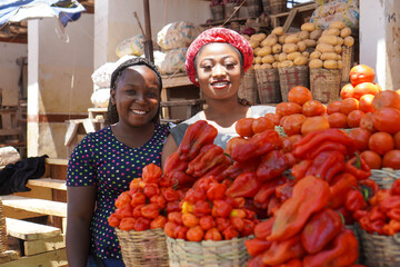 Beautiful African women selling fresh vegetables at the farmers market