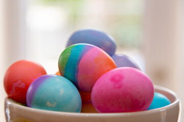 Close up bowl of brightly colored Easter eggs on diplay