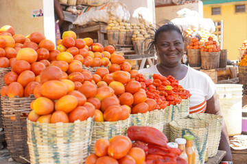Happy African woman selling fruits and vegetables at the farmers market