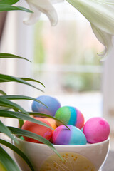 Bowl of brightly colored Easter eggs on diplay in kitchen window