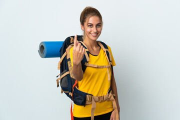 Young mountaineer woman with a big backpack isolated on white background doing coming gesture