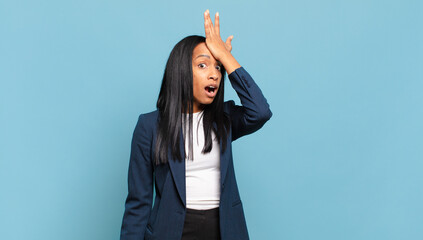 young black woman raising palm to forehead thinking oops, after making a stupid mistake or...