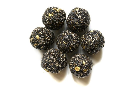 Indian sweet sesame seeds ladoo, known as Ellunda in Kerala, isolated on a white background.